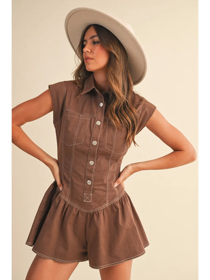 Woman wearing a brown sleeveless dress with buttons and a beige hat on a beige background