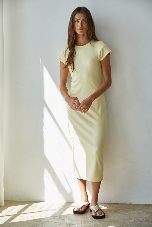 Model wearing the Sylva Bodycon Midi Dress in soft yellow with short sleeves and bodycon fit