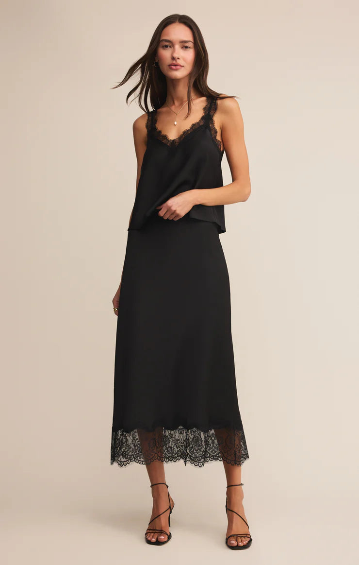 Black satin midi skirt with scalloped lace hem and high-rise waistband styled with strappy heels.
