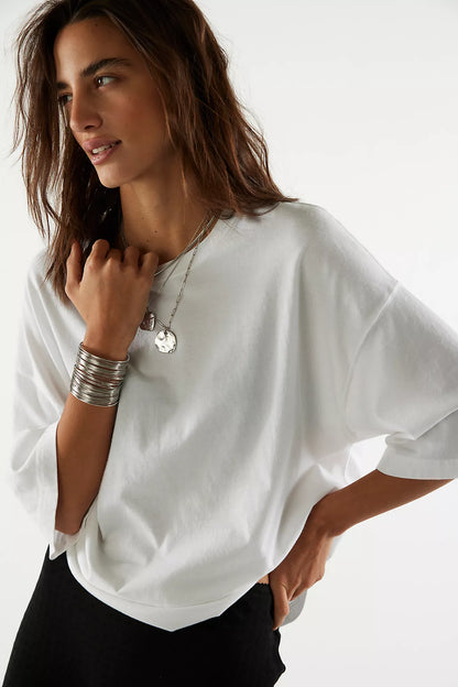 Model wearing oversized white cotton tee with relaxed boxy fit and dropped shoulders